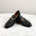 Black leather horsebit loafers with gold hardware